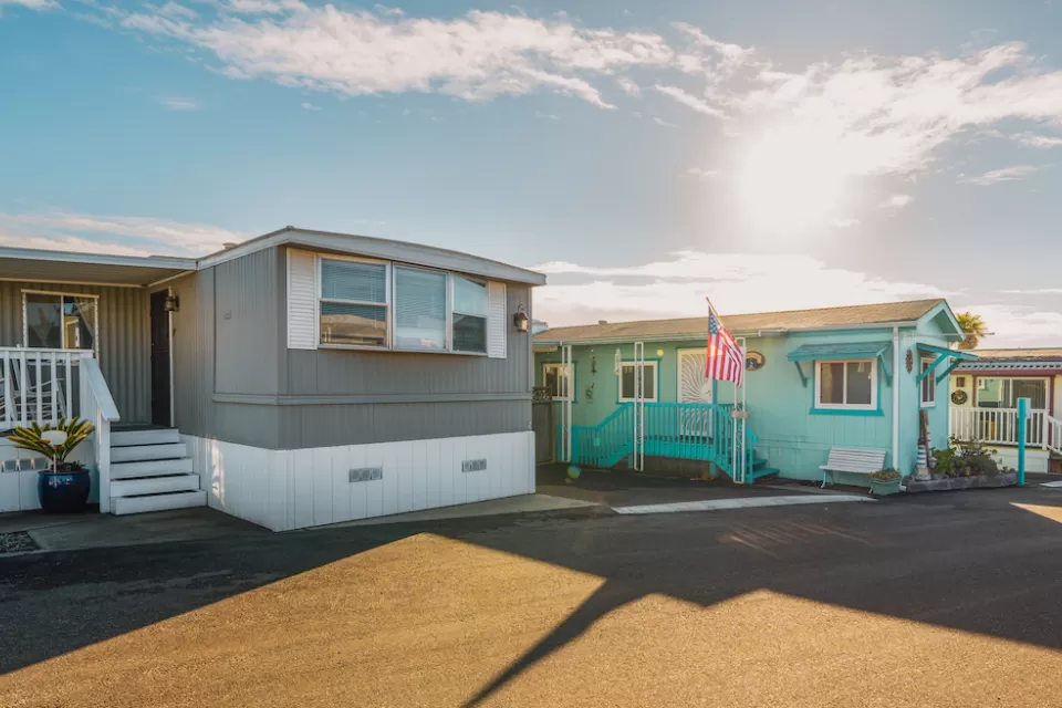 Row of colorful mobile homes on an asphalt street.